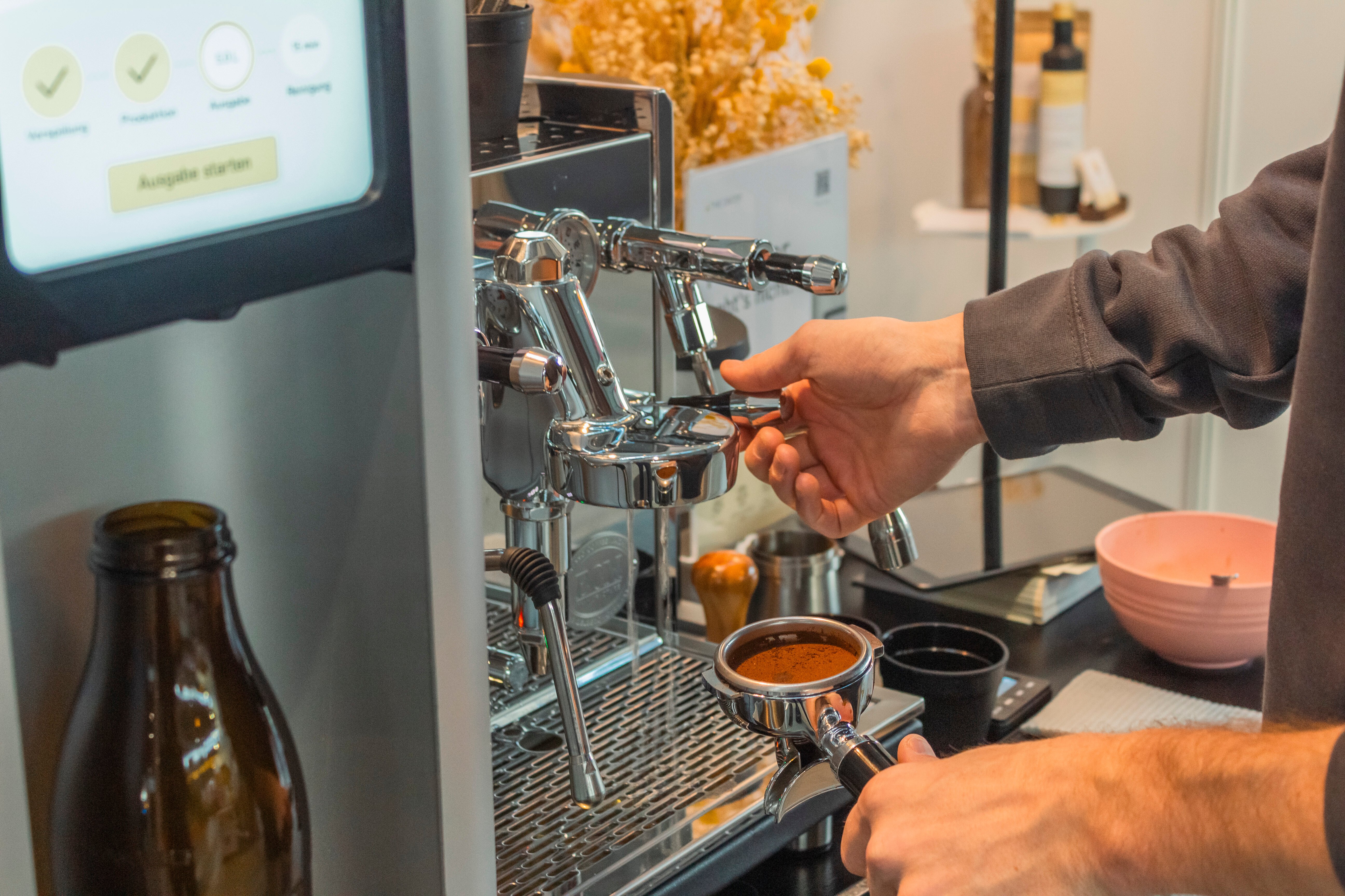 Barista bedient Siebträger Maschine neben Haferdrink Maschine